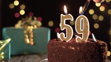 Doğum günü mumu 59 numara masadaki tatlı kekin üstünde, 59. doğum günü. Çakmağı yak, bayram mumunu söndür..