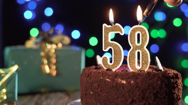 Narozeninová svíčka číslo padesát osm na sladkém dortu na stole, 58. narozeniny. Oheň ze zapalovače, sfoukni sváteční svíčku. — Stock video