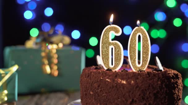 Numero sessanta candela di compleanno sulla torta dolce sul tavolo, sessantesimo compleanno. Fuoco dall'accendino, spegnete la candela natalizia. — Video Stock