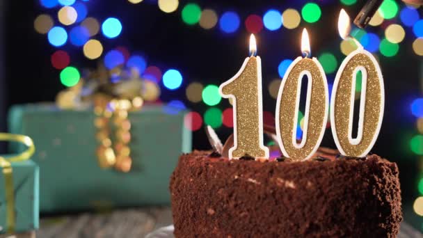Hundra födelsedagsljus på tårta på bordet, 100-årsdag. Eld från tändaren, blåsa ut julljuset. — Stockvideo