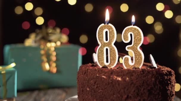 Födelsedagsljus nummer åttiotre på en söt tårta på bordet, 83-årsdag. Eld från tändaren, blåsa ut julljuset. — Stockvideo