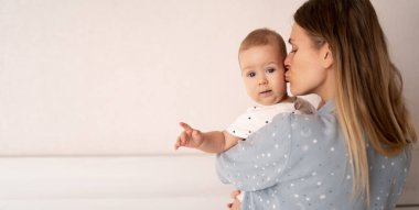 Beyaz anne ve bebek kızı kollarında, bir kadın çocuğunu, ailesini, anneliğini, ebeveynliğini, insanlarını ve çocuk bakımını kucaklıyor ve öpüyor. Pankart, metin için yer.
