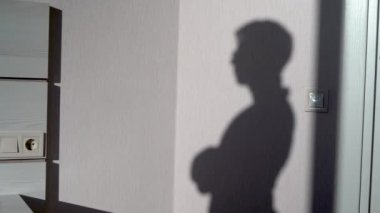 Beyaz tuğlalı duvara gözlük takan adamın gölgesi ofis içi iç plan, ev hayaleti.