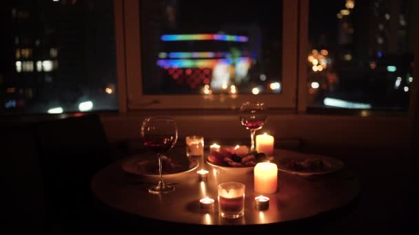 Valentýn, sklenice s červeným vínem a večeře na stole, sklenice a jídlo pro 14. února, rande bez lidí, bokeh září v pozadí — Stock video