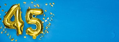Kırk beş numaralı altın folyo balonu. Doğum günü ya da yıldönümü kartı. Üzerinde 45 yazılıydı. Mavi beton arka plan. Yıldönümü kutlaması. Pankart. Boşluğu kopyala