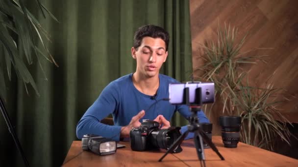 Videoträning för nybörjare fotografer, onlinekurser. En Muselman håller en pack av en hundra dollar räkningar i hans händer och räknar pengar. Begreppet info företag och sälja kurser på nätet. — Stockvideo