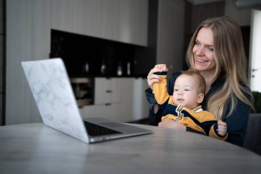 Avrupalı beyaz bir bebeği olan beyaz bir anne internet üzerinden evden çalışıyor. Çocuğuyla birlikte serbest çalışan bir kadının işyeri. Evde kalıp uzaktan çalışan bekâr bir anne olacaksın..