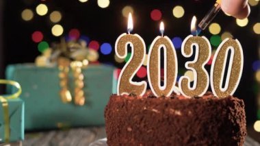 - Mutlu yıllar. 2030 'da masadaki tatlı kekin üzerine iki bin otuz numaralı altın mum. Çakmağı yak, bayram mumunu söndür..