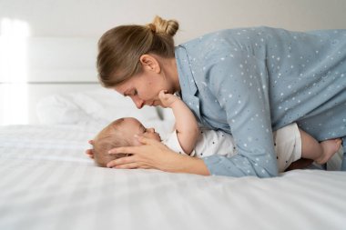 Kafkasyalı anne sabah 4 aylık bebeği öpüyor, mutlu annelik kavramı.