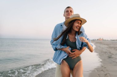 Gülümseyen mutlu genç bir çift, mavi gömlekli bir adam ve bir kadın, kızın diş tellerini neşeyle sarılıp yıkarlar. Tatil konsepti. Boşluğu kopyala.