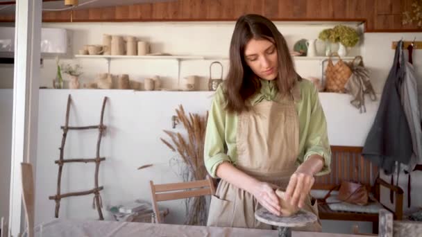Ung kaukasisk vacker kvinna i förkläde njuter av att arbeta med lera i hantverk verkstad. — Stockvideo