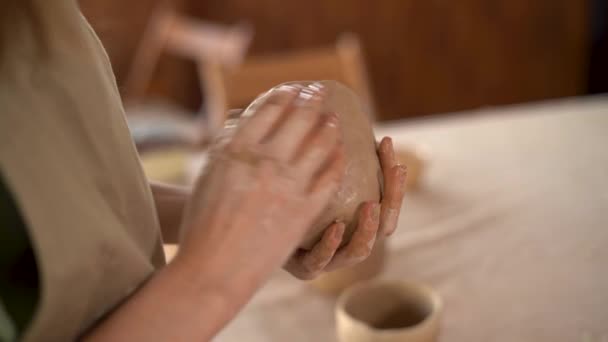 Kvinnliga krukmakare hand skulptera en lerkruka med händerna. Kvinna keramik arbetar med rå lergods, skapa handgjorda keramik. Fukta leran med vatten. Kompetens- och småföretagskoncept — Stockvideo