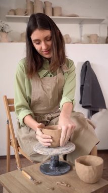 Dikiş sanatçısı formlarının yaratıcı süreci ve el oymacılığı çömlekçilik. Kadın çömlekçinin hammaddeyle çalışıp el yapımı seramik ürettiği bir atölyede çalışma masası..