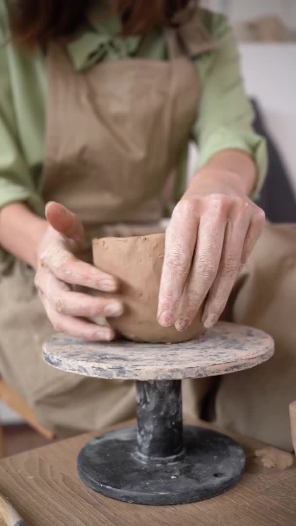 Fabricación de productos de arcilla, cerámica, fabricación de cerámica, DIY. una mujer con sus manos esculpe un producto de arcilla en movimiento. El primer plano de Potters funciona. Potter rueda arcilla. Hecho a mano. — Vídeos de Stock