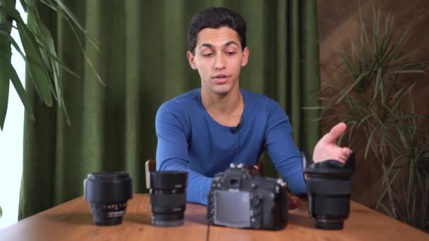 初心者の写真家のためのビデオトレーニング、オンラインコース。イスラム教徒の男性はカメラを見て、レンズの異なる種類について話します。情報ビジネスの概念とオンライン販売コース. — ストック動画
