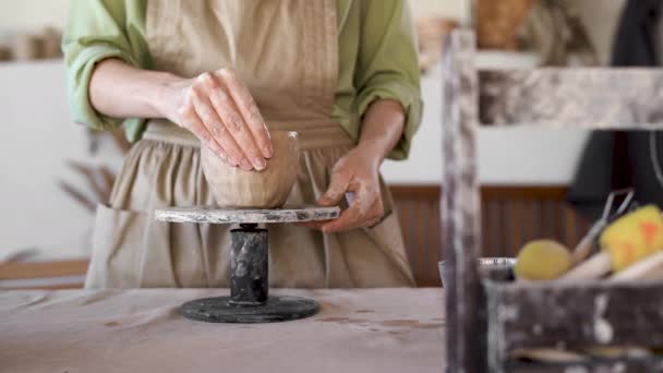DIY work close-up of a creative womans hand sculpting raw clay on a potters wheel by shaping pottery in a pottery art workshop. tools for a craftsman. — Stock Video