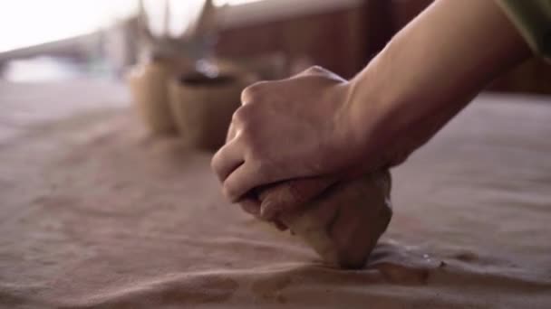 As mãos femininas de um oleiro amassam e formam uma parte suave e molhada de barro branco. Preparação de material de argila para fazer panelas artesanais. Cerâmica no processo de ser feito close-up. Escultura mão argila — Vídeo de Stock
