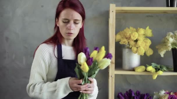 Kobieta trzyma piękny bukiet kwiatów tulipanów w różnych kolorach. Kwiaciarnia z jego pracy. — Wideo stockowe