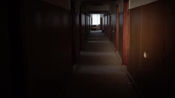 Інтер'єр або темний коридор покинутої будівлі після війни освітлюється вночі ліхтарем, брудними стінами. Зйомки від першої особи, що проходить через коридори готелю . — стокове відео