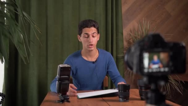 Fotografiestunde. Ein junger muslimischer Mann nimmt eine Videostunde mit einer Kamera auf und spricht über Komposition in der Fotografie. Heimvideostudio. Professionelle Fotografen bloggen — Stockvideo