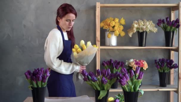 Kwiaciarnia właściciel firmy w pracy, ładna młoda dama robi modny nowoczesny bukiet tulipanów. wkłada bukiet i masuje szyję. pojęcie zmęczenia i przepracowania w miejscu pracy. — Wideo stockowe