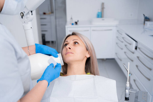 Dentist's hands take a jaw x-ray for a young woman in a dental clinic. .Concept of dental treatment. copy space.