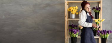 Küçük bir iş. Çiçekçinin yanında laleli bir çiçekçi kadın telefonla sipariş alır. Çiçek tasarım stüdyosu, dekor yapımı. Çiçek teslimatı, sipariş. Pankart. Boşluğu kopyala.
