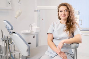 Kadın bir dişçinin portresi. O, dişçisinin ofisinde bir sandalyede oturuyor. Boşluğu kopyala
