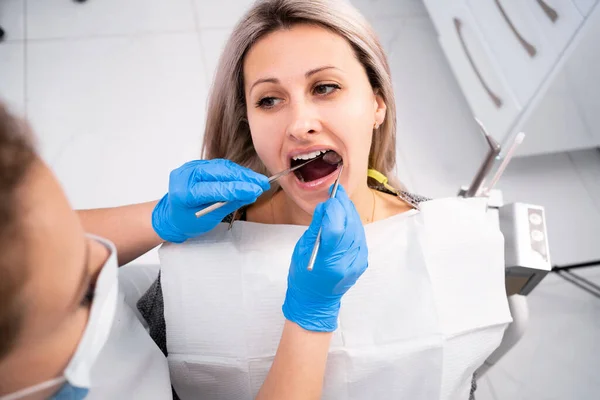 Profesjonalny Dentysta Bada Leczy Uszkodzone Zęby Pomocą Specjalnych Przyrządów Stomatologicznych — Zdjęcie stockowe