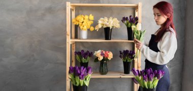 Küçük bir iş. Çiçekçide çalışan bir kadın. Çiçek tasarım stüdyosu, dekorasyon ve düzenlemeler. Çiçek teslimatı, düzen oluşturma. Boşluğu kopyala.