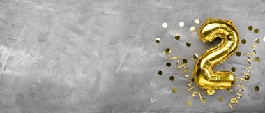 Sarı folyo balon numarası, beton arka planda iki numara. 2 harfli doğum günü kartı. Yıldönümü konsepti. Yıldönümü, doğum günü, yeni yıl kutlaması için. afiş, boşluğu kopyala.