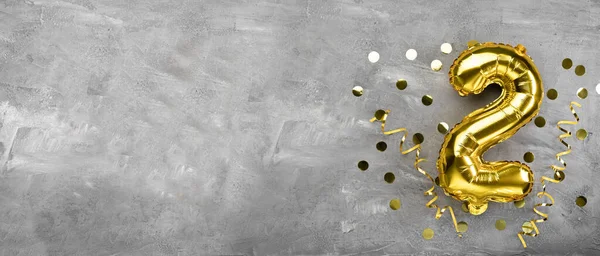Sarı folyo balon numarası, beton arka planda iki numara. 2 harfli doğum günü kartı. Yıldönümü konsepti. Yıldönümü, doğum günü, yeni yıl kutlaması için. afiş, boşluğu kopyala.