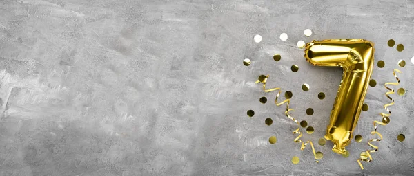 Sarı folyo balon numarası, beton arka planda yedi numara. Üzerinde 7 yazan doğum günü kartı. Yıldönümü konsepti. Yıldönümü, doğum günü, yeni yıl kutlaması için. afiş, boşluğu kopyala.