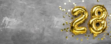 Sarı folyo balon numarası, 28 numara beton arka planda. 28 yazıtlı doğum günü kartı. Yıldönümü konsepti. Yıldönümü, doğum günü, yeni yıl kutlaması için. afiş, boşluğu kopyala.