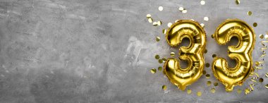 Sarı folyo balon numarası, 33 numara beton arka planda. 33. yaş günü kartı. Yıldönümü konsepti. Yıldönümü, doğum günü, yeni yıl kutlaması için. afiş, boşluğu kopyala.