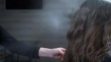 Profesyonel kuaför saçını ve saç modelini düzeltmek için saç spreyi kullanır..