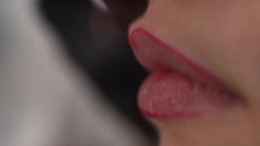Dudak makyajı. Renkli dudak kalemi süren genç ve güzel bir kadının yakın çekimi. Kız dudak kalemiyle, kozmetik ürünleriyle seksi dolgun dudaklar yapıyor. Kalıcı kozmetik konsepti.