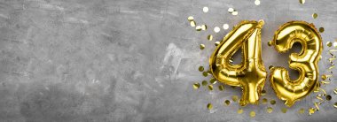 Sarı folyo balon numarası, kırk üç numara beton arka plan. Üzerinde 43 yazan tebrik kartı var. Yıldönümü konsepti. Yıldönümü, doğum günü, yeni yıl kutlaması için. afiş, boşluğu kopyala.