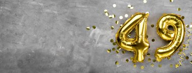 Sarı folyo balon numarası, 49 numara beton arka plan. 49. yazıyla birlikte tebrik kartı. Yıldönümü konsepti. Yıldönümü, doğum günü, yeni yıl kutlaması için. afiş, boşluğu kopyala.