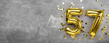 Sarı folyo balon numarası 57 numara beton arka plan. Üstünde 57 yazan tebrik kartı var. Yıldönümü konsepti. Yıldönümü, doğum günü, yeni yıl kutlaması için. afiş, boşluğu kopyala.