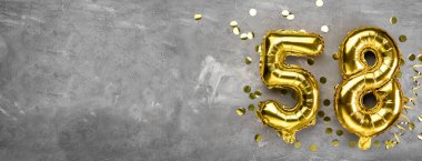 Sarı folyo balon numarası, beton arka planda 58 numara. Üstünde 58 yazan tebrik kartı var. Yıldönümü konsepti. Yıldönümü, doğum günü, yeni yıl kutlaması için. afiş, boşluğu kopyala.