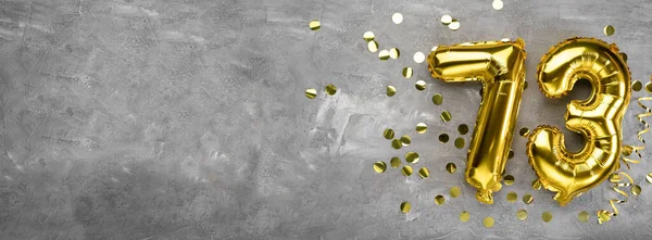 Sarı folyo balon numarası, 73 numara beton arka planda. Üstünde 73 yazan tebrik kartı var. Yıldönümü konsepti. Yıldönümü, doğum günü, yeni yıl kutlaması için. afiş, boşluğu kopyala.
