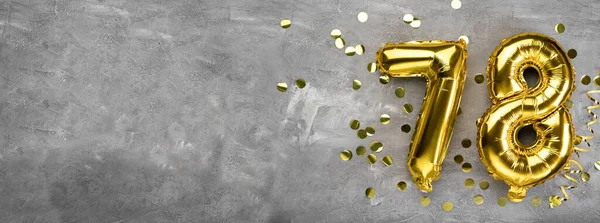 Sarı folyo balon numarası, 78 numara beton arka planda. Üzerinde 78 yazan tebrik kartı var. Yıldönümü konsepti. Yıldönümü, doğum günü, yeni yıl kutlaması için. afiş, boşluğu kopyala.