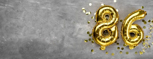 Sarı folyo balon numarası, beton arka planda 86 numara. 86 yazısıyla birlikte tebrik kartı. Yıldönümü konsepti. Yıldönümü, doğum günü, yeni yıl kutlaması için. afiş, boşluğu kopyala.
