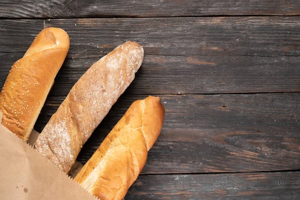 Três Baguetes Francesas Crocantes Num Fundo Madeira Num Saco Papel — Fotografia de Stock