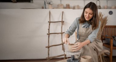 Dikiş işi yapan kadın sanatçıların yaratıcı süreci çömlek kalıpları ve el modelliği ile ilgilidir. Çömlekçinin el işi çömlek yapmak için hammaddelerle çalıştığı atölyedeki çalışma masası. Boşluğu kopyala