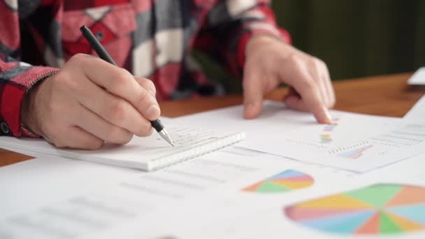 Homme caucasien, investisseur d'affaires ou client analyse les avantages dans le document statistique du projet avec des graphiques croissants, vérifie le résultat financier dans le rapport à la réunion, close-up — Video