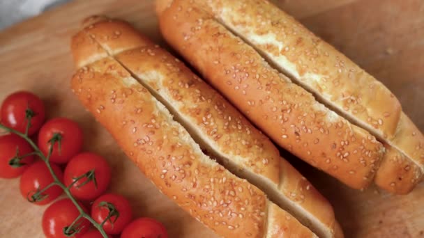 Les mains féminines du cuisinier mettent la saucisse dans le pain. Le processus de fabrication d'un hot dog à la maison. — Video