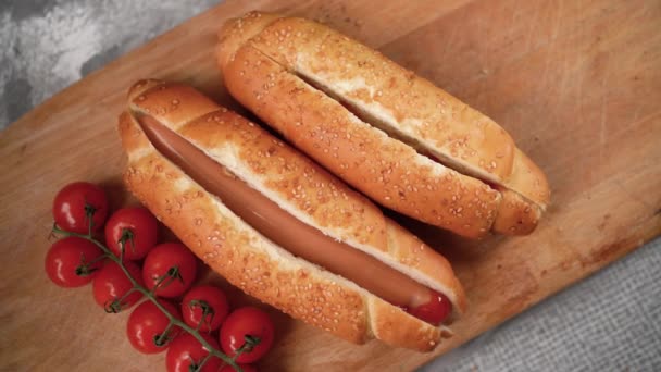 A szakács kolbászt tesz egy hot dogos zsemlébe. Gyorsétterem, recept, — Stock videók