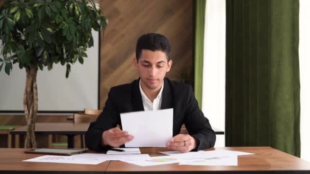 Erfolgreicher arabischer Jungunternehmer liest in einem Café Zeitungen, Dokumente werden vom Direktor untersucht, ein Führer bereitet Berichte vor — Stockvideo